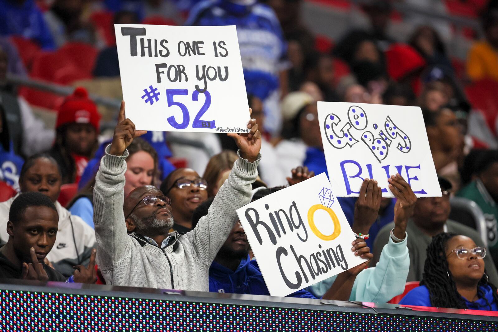 Manchester fans hold signs including one in honor of former Manchester defensive lineman Brandon Smith (52) during their game against Bowdon during the Class A Division II GHSA State Championship game at Mercedes-Benz Stadium, Monday, December. 11, 2023, in Atlanta. Brandon Smith was found dead on Sunday night, just hours before Manchester was scheduled to play Bowdon. (Jason Getz / Jason.Getz@ajc.com)