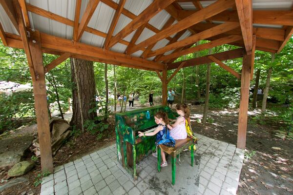 Sadie Preis of Dunwoody and her sister Jillian play on a piano named at the Dunwoody Nature Center in 2018. Local officials hope things like the nature center will attract visitors to explore Dunwoody. (JASON GETZ)