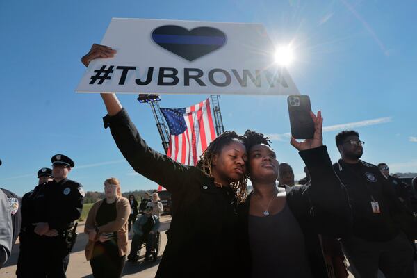 St. Louis County police officers Ashley Wallace, left, and Shawntice Midgett, join hundreds of family, friends and fellow officers as they send off injured Ferguson police officer Travis Brown to a specialized rehabilitation hospital Tuesday, Nov. 12, 2024, at Spirit of St. Louis airport in Chesterfield, Mo. (Laurie Skrivan/St. Louis Post-Dispatch via AP)