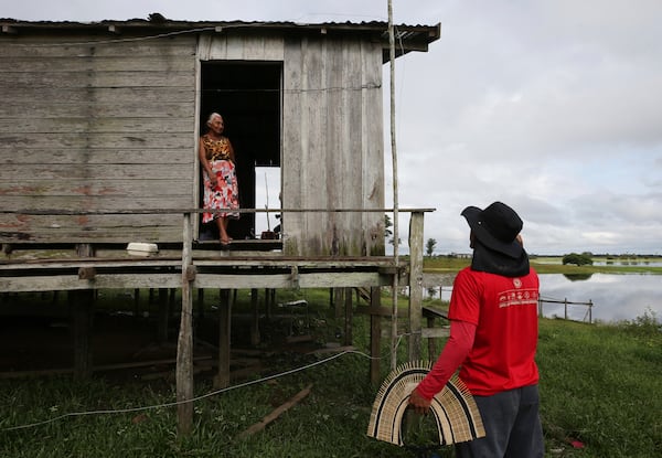 Indigenous leader Filipe Gabriel Mura talks with his aunt in the Lago do Soares village in Autazes, Amazonas state, Brazil, Feb. 18, 2025. (AP Photo/Edmar Barros)