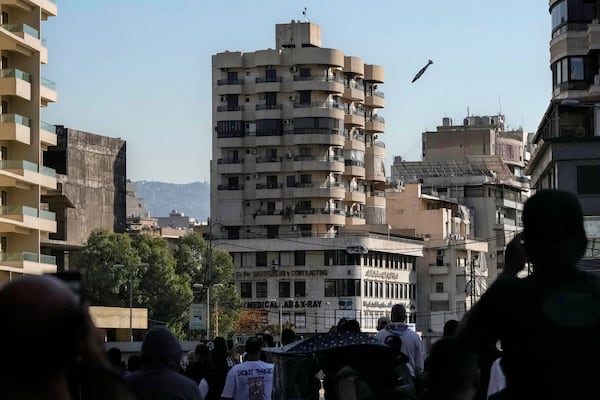 People look as a munition launched by Israeli forces makes its way to hit a building in Chiyah, in the southern suburb of Beirut, Lebanon, Friday, Nov. 22, 2024. (AP Photo/Bilal Hussein)