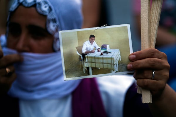 FILE - A supporter of pro-Kurdish People's Democratic Party (HDP), holds a picture of the party's former co-leader Selahattin Demirtas, currently in Turkish prison on charges of leading a terror organisation, as she participates in a rally in Istanbul, Thursday, June 18, 2020. (AP Photo/Emrah Gurel, File)