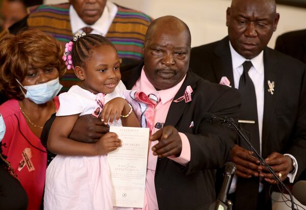 081122 Atlanta, Ga.: Marvin Grier holds up one of his granddaughters during the celebration of life for his daughter Brianna Grier at West Hunter Street Baptist Church, Thursday, August 11, 2022, in Atlanta. Grier is the woman who died after Hancock Police officers left the door open on the back of the police car after arresting her. Brianna is survived by her two twin daughters, one of which pictured. (Jason Getz / Jason.Getz@ajc.com)