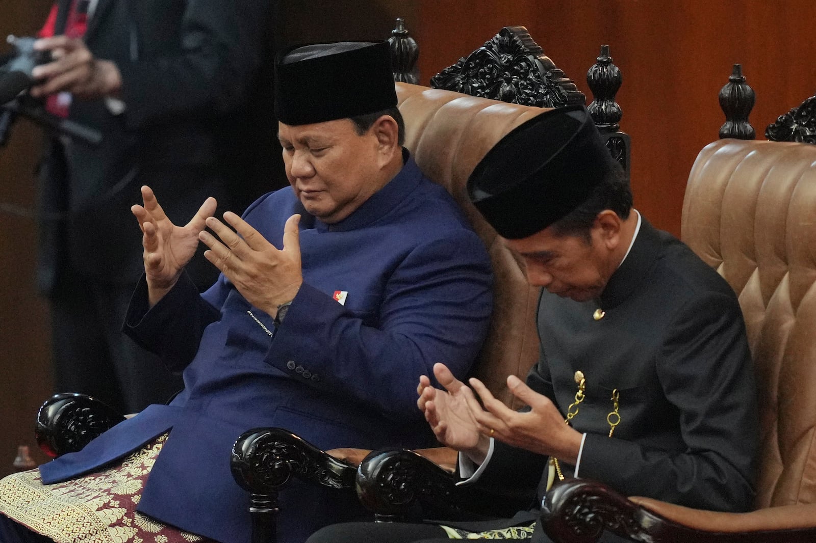 Indonesia's newly-inaugurated President Prabowo Subianto, left, and his predecessor Joko Widodo pray during his swearing in ceremony at the parliament building in Jakarta, Indonesia, Sunday, Oct. 20, 2024. (AP Photo/Tatan Syuflana)