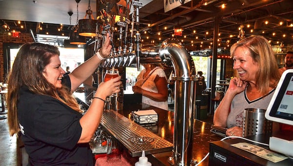 Bartender Lauren Kell shares a laugh with a customer during happy hour at Glover Park Brewery. CONTRIBUTED BY CHRIS HUNT PHOTOGRAPHY