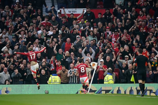 Manchester United's Bruno Fernandes, center, celebrates scoring his side's opening goal during the English Premier League soccer match between Manchester United and Arsenal at Old Trafford stadium in Manchester, England, Sunday, March 9, 2025. (AP Photo/Dave Thompson)