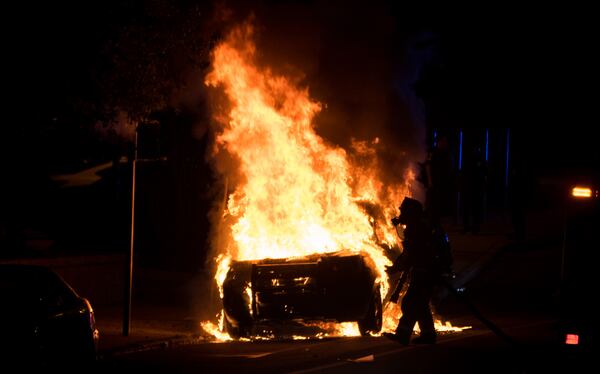  Two officers were injured and a police car was torched Monday night. Photo: special to the AJC