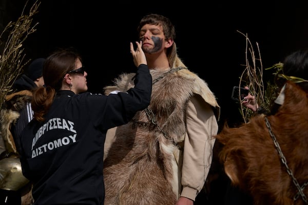 Revellers dressed in animal skins and heavy bronze bells, prepare to take part in carnival celebrations in Distomo, a village in central Greece, on Monday, March 3, 2025. (AP Photo/Petros Giannakouris)