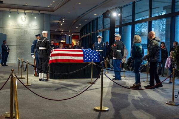 Mourners view the casket of former President Jimmy Carter as he lies in repose at the Carter Presidential Center in Atlanta, Sunday, Jan. 5, 2025. Carter died Dec. 29th at the age of 100. (AP Photo/Alex Brandon, Pool)