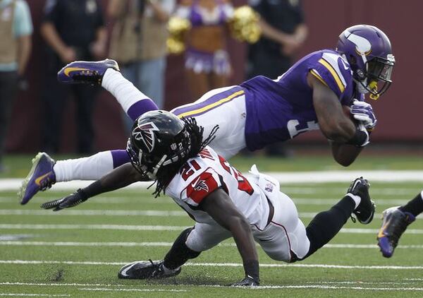 Minnesota Vikings running back Jerick McKinnon is tackled by Atlanta Falcons cornerback Desmond Trufant (21) during the first half of an NFL football game, Sunday, Sept. 28, 2014, in Minneapolis. (AP Photo/Ann Heisenfelt)