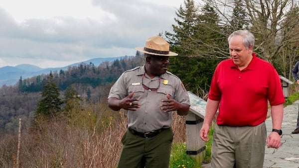 This Wednesday, May 6, 2020 image from a tweet by Interior Secretary David Bernhardt, the Interior Secretary visits with National Parks Service employees at Great Smoky Mountains National Park. While the Interior Secretary asked visitors to social distance when the park reopens on May 9, neither Bernhardt nor park staff wore face masks in the photos, as they talked and walked inches apart during his visit on Tuesday, May 5.  (National Parks Service via AP)