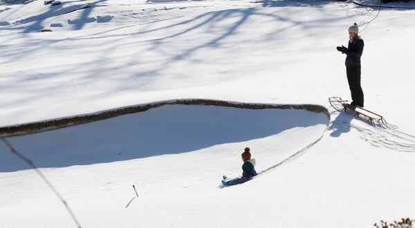 1/17/18 - Atlanta -   Greer Glover, 3, does some sledding at Ansley Golf Club in Atlanta with her mother, Melissa.   With temperatures in the teens, overnight snowfall is expected to remain into Thursday.   Gov. Deal declared a state of emergency in 83 Georgia counties for Wednesday, Jan. 17.  BOB ANDRES  /BANDRES@AJC.COM