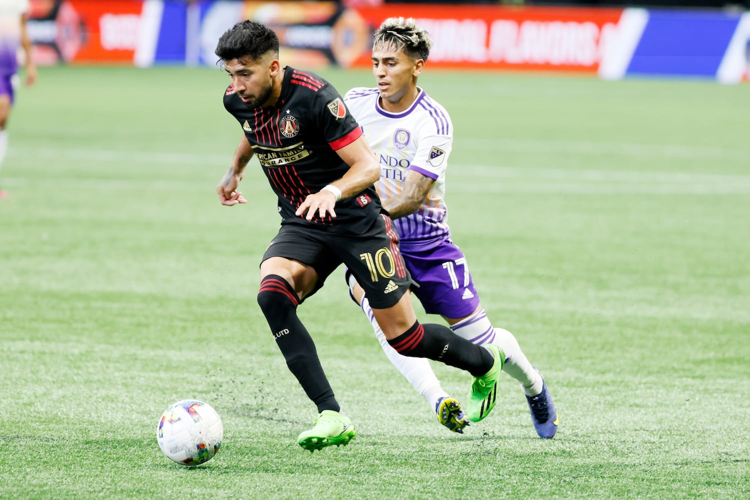 Atlanta United's Marcelino Moreno dribbles, leaving behind Orlando midfielder Facundo Torres during the second half Sunday at Mercedes-Benz Stadium. (Miguel Martinez /Miguel.martinezjimenez@ajc.com)