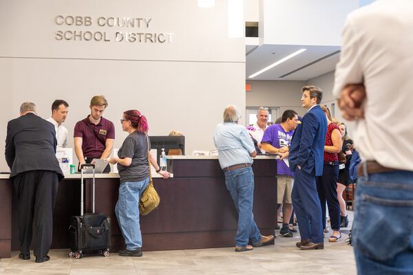 People sign up for public comment before a Cobb County school board meeting in Marietta on Thursday, Aug. 17, 2023. (Arvin Temkar / arvin.temkar@ajc.com)