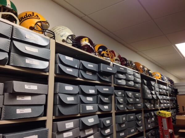 The helmets were all worn by hall of fame members. He mentioned some of them. John Friesz' Idaho Vandals helmet is up front. The boxes below the helmets are full of game programs.