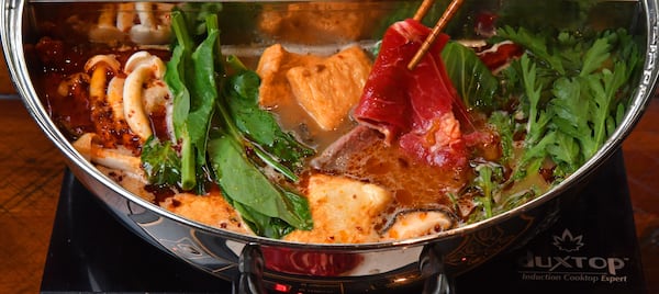 Todd Dae Kulper simmers thinly sliced beef in his Sichuan Spicy Hot Pot. Styling by Todd Dae Kulper. (CHRIS HUNT FOR THE ATLANTA JOURNAL-CONSTITUTION)