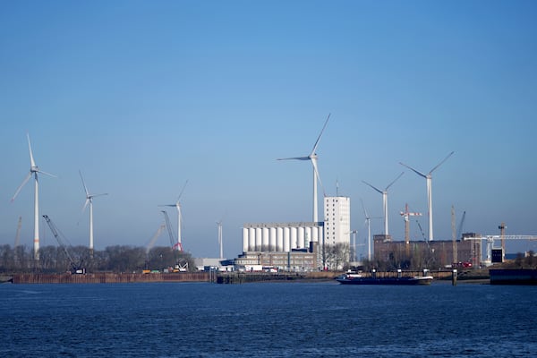 Wind turbines in front of industrial businesses along the River Scheldt in Antwerp, Belgium, Wednesday, Feb. 26, 2025. (AP Photo/Virginia Mayo)