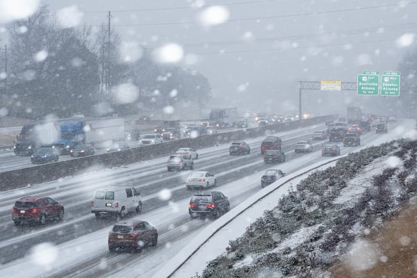 Traffic slows on I-285 in Tucker as snow falls on Tuesday.