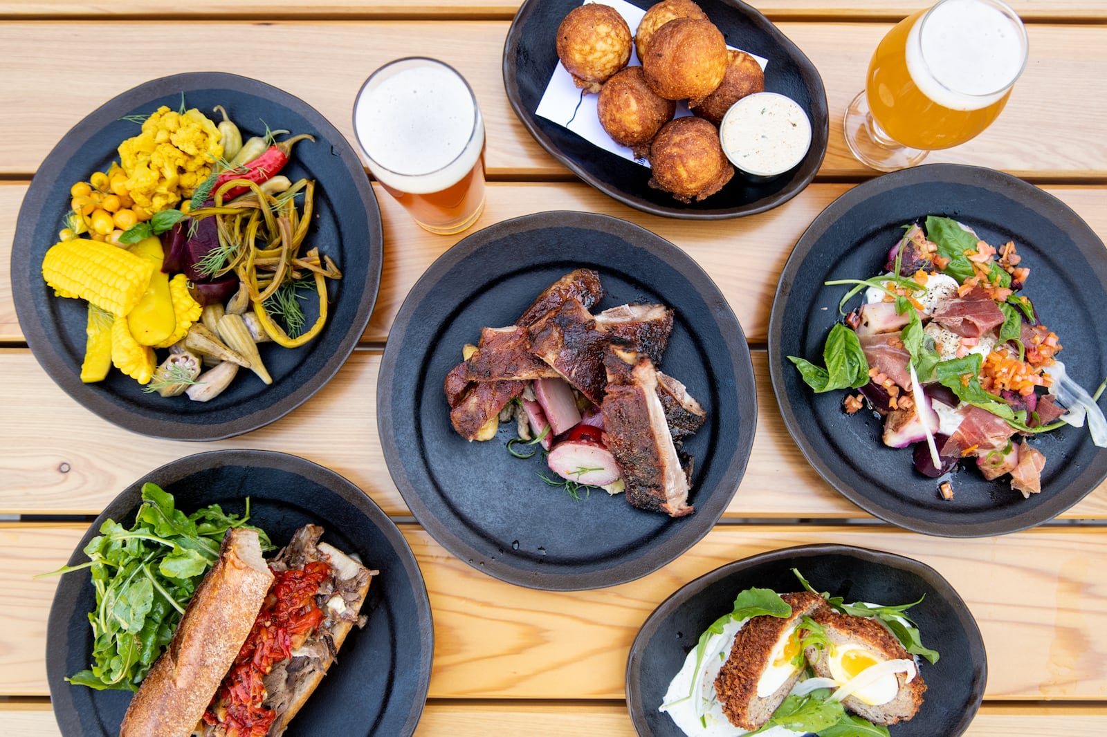 Biggerstaff Honey Butter Ribs, Atlanta Egg, Pickles, Cornbread Bites, Warm Burrata, and Smoked Brisket Sandwich. (Mia Yakel for The Atlanta Journal-Constitution)