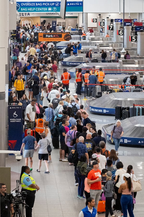 People wait in a long line leading to the Bag Help Center at Hartsfield-Jackson Atlanta International Airport Saturday after hundreds of airline flights were canceled due to a global technology outage on Friday.   (Steve Schaefer / AJC)