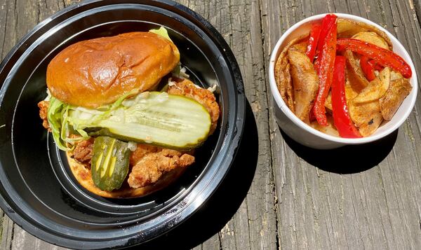 Poach Social serves a nice fried chicken sandwich, shown here with a side of potato medallions.
Wendell Brock for The Atlanta Journal-Constitution