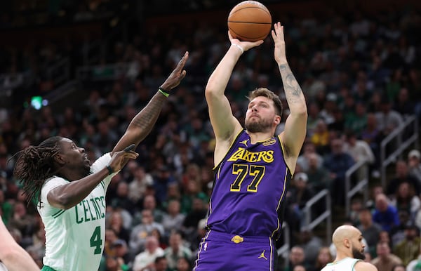 Los Angeles Lakers guard Luka Doncic (77) shoots over Boston Celtics guard Jrue Holiday (4) during the first half of an NBA basketball game, Saturday, March 8, 2025, in Boston. (AP Photo/Mark Stockwell)