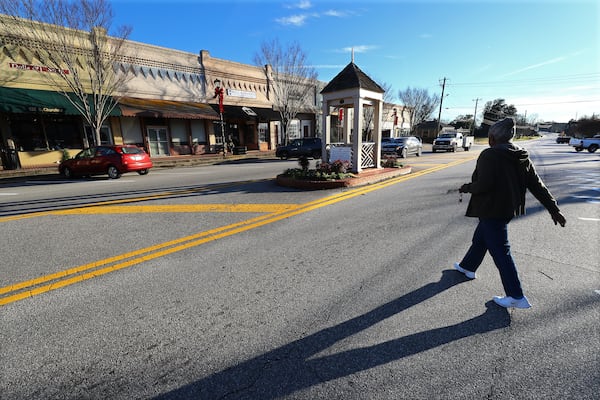  Local resident Ann Lowe, 78, doesn't need a cross-walk to make her way back to her car on the other side of the main drag in downtown Social Circle after going to a store in the small Georgia town on Tuesday, Jan. 18, 2022. (Curtis Compton / Curtis.Compton@ajc.com)`