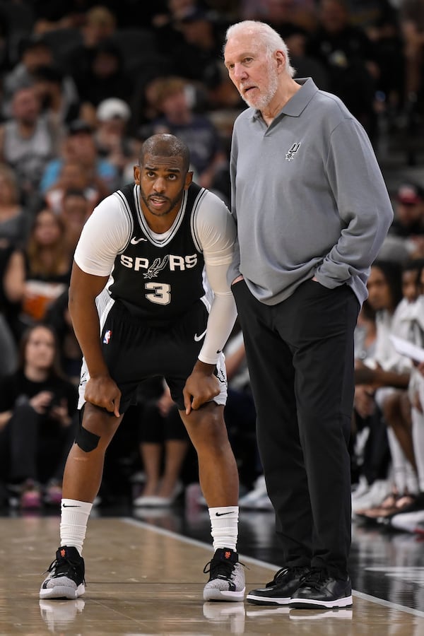 San Antonio Spurs head coach Gregg Popovich, right, speaks with Spurs guard Chris Paul, left, during the first half of an NBA basketball game against the Houston Rockets, Monday, Oct. 28, 2024, in San Antonio. (AP Photo/Darren Abate)