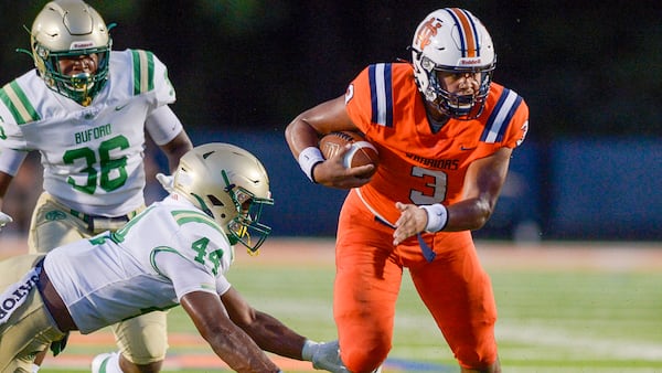 North Cobb QB Malachi Singleton (3) dodges a tackle from Buford linebacker Aubrey Smith (44) in the first half of Friday's game. (Daniel Varnado/Special to the AJC)