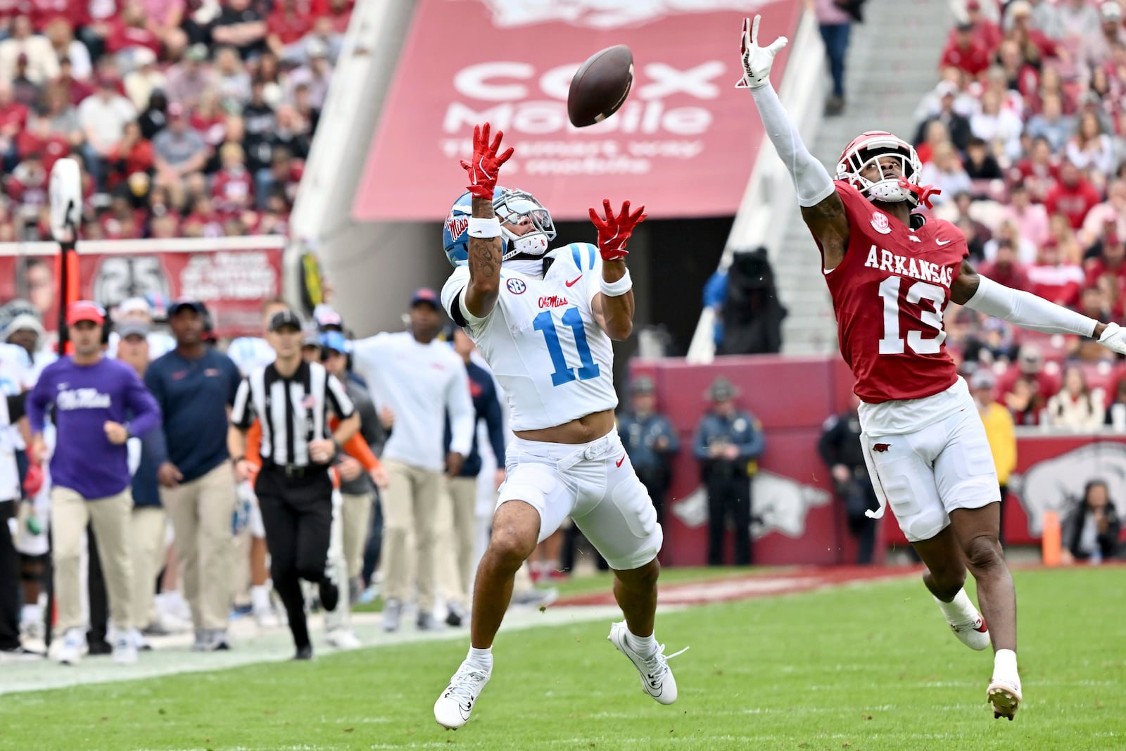 Mississippi wide receiver Jordan Watkins (11) pulls in a pass for a 62-yard touchdown in front of Arkansas defensive back Marquise Robinson (13) during the first half of an NCAA college football game Saturday, Nov. 2, 2024, in Fayetteville, Ark. (AP Photo/Michael Woods)