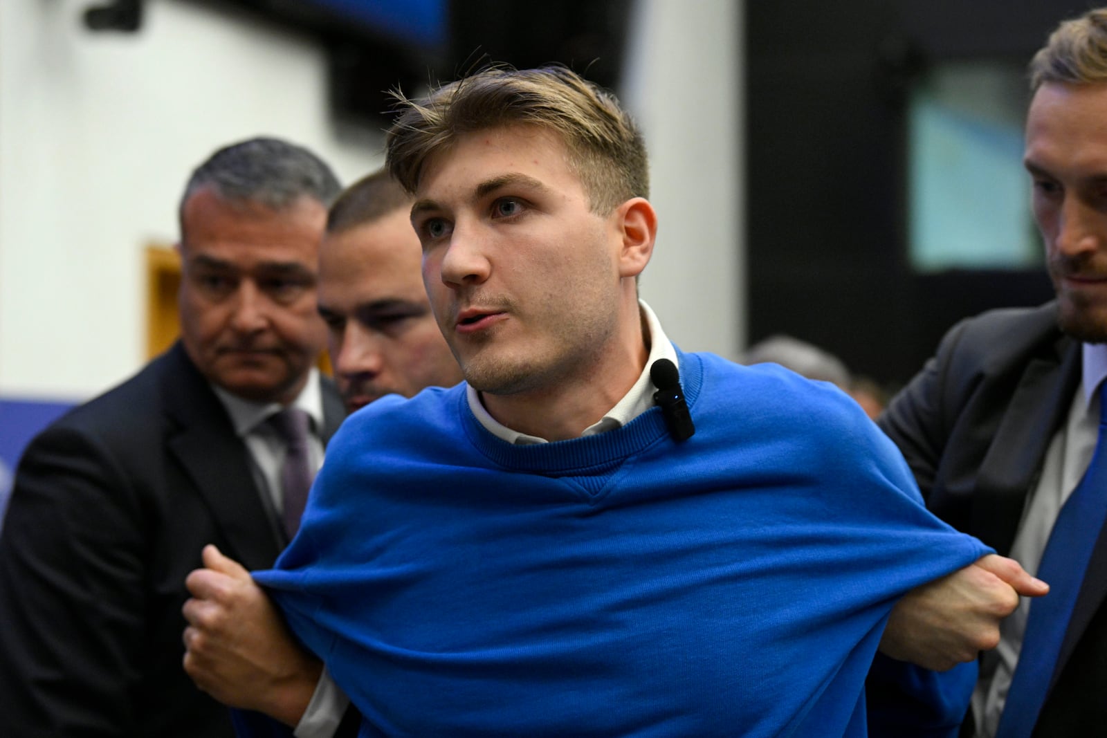 Security officers lead away a man, who disrupted the press conference of Hungarian Prime Minister Viktor Orban ahead of a plenary session at the European Parliament in Strasbourg, France, Tuesday, Oct. 8, 2024. (Tamas Purger/MTI via AP)