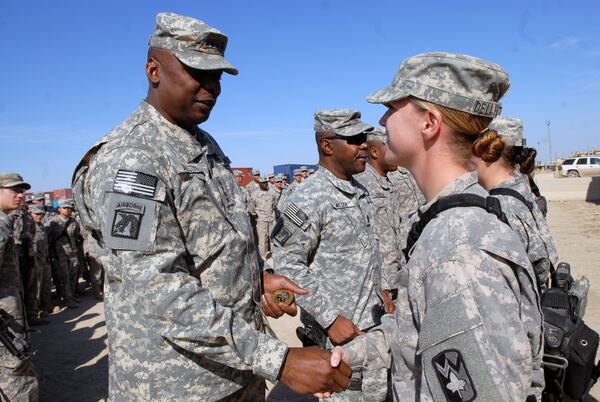 Gen. Lloyd Austin, commanding general for United States Forces-Iraq, coins Sgt. Tara De la Fuente of the 4th Sustainment Brigade, 310th Expeditionary
Sustainment Command Nov. 24 at Contingency Operating Base Adder, Iraq. Austin visited with Col. Ron Kirklin, commander for the 4th Sust. Bde., while also coining soldiers and taking time to talk with them and take photos.