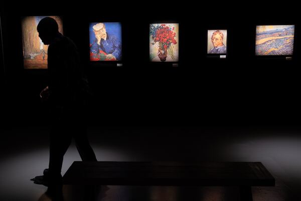 Dr. Monty Whitney strolls through the first room of Van Gogh: The Immersive Experience at Exhibition Hub Art Center Atlanta in Doraville on Monday, July 31, 2023, while visiting the exhibit with his wife Bettye.  (Ben Gray / Ben@BenGray.com)