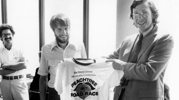 Members of the Atlanta Track Club present Jim Cox Kennedy the 1976 AJC Peachtree Road Race T-shirt