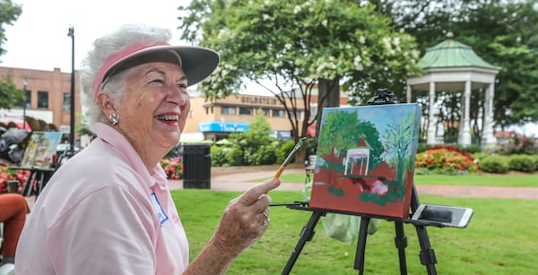 Janet Carpenter painting on the Marietta Square in 2021. The land for the square was donated by the Glover family early in the town's history. The Glovers also led a fight to save the square from becoming a parking lot in the 1970s. John Spink/AJC 2021

