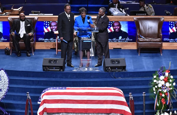 March 13, 2015 College Park - Bertha Green, mother of Fulton County Detective Terence Green, speaks as her husband Johnny Green (left) stands next her during a funeral service at World Changers International Church on Friday, March 13, 2015. Terence Avery Green, 48, was on duty March 4 when he was killed in what a Fulton police assistant chief called an ambush-style attack. HYOSUB SHIN / HSHIN@AJC.COM