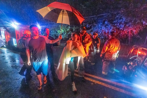 Atlanta Fire Rescue’s Dive/Swift Water Team rescued a family from the top of their vehicle amid fast-moving water on Bohler Road in Atlanta early Friday morning. Helene, which entered Georgia as a Category 2 hurricane Friday morning, Sept. 27, 2024 downgraded to a tropical storm but brought a lot of problems to Atlanta with numerous water rescues and incessant rain. More than 1.1 million power outages have been reported statewide, and flash flooding remained a major concern. (John Spink/AJC)