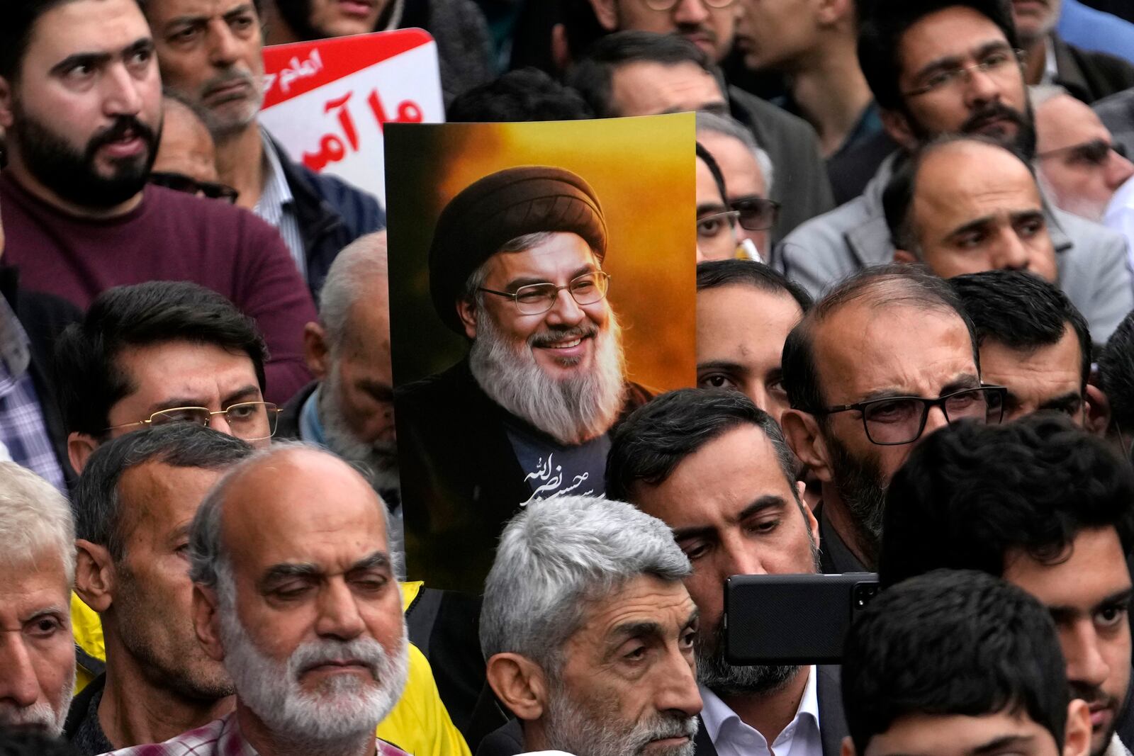 An Iranian demonstrator holds up a poster of the slain Hezbollah leader Hassan Nasrallah at the annual rally in front of the former U.S. Embassy in Tehran, Iran, Sunday, Nov. 3, 2024, marking the 45th anniversary of Iranian students' takeover of the embassy, starting a hostage crisis. (AP Photo/Vahid Salemi)