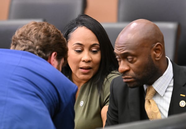 Fulton County District Attorney Fani Willis (center) confers with lead prosecutors, Donald Wakeford (left) and Nathan Wade, during a motion hearing at Fulton County Courthouse in Atlanta on Friday, July 1, 2022. (Hyosub Shin / Hyosub.Shin@ajc.com)