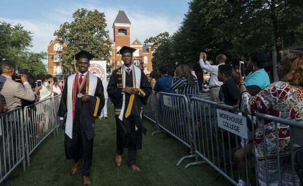 Morehouse College Valedictorian Derrick Parker, left, and Salutatorian Matthew B. Young walk to their seat as their graduation ceremony get underway Sunday. Parker is the first in his family to graduate college while Young follows in the footsteps of his father, Harding Young, a member of the first graduating class at the Morehouse School of Medicine in 1981. Contributed