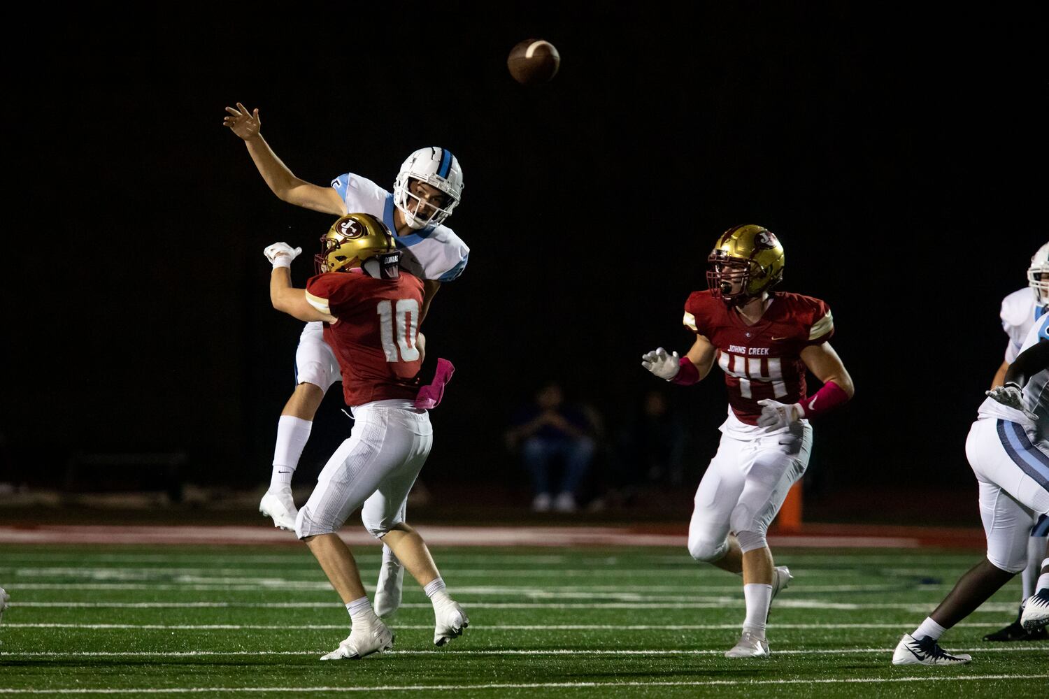 Cambridge quarterback Zach Harris (15) is tackled during a GHSA high school football game between Cambridge High School and Johns Creek High School in Johns Creek, Ga. on Friday, October 15, 2021. (Photo/Jenn Finch)