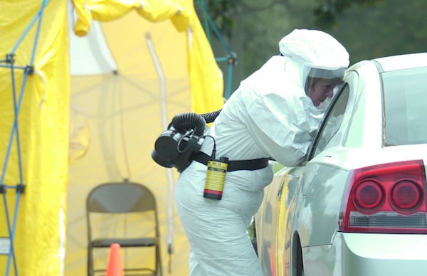 A medical professional in protective equipment swabs a potential COVID-19 patient at a Phoebe Putney Health System drive-through testing site in the Albany area. SPECIAL TO THE AJC