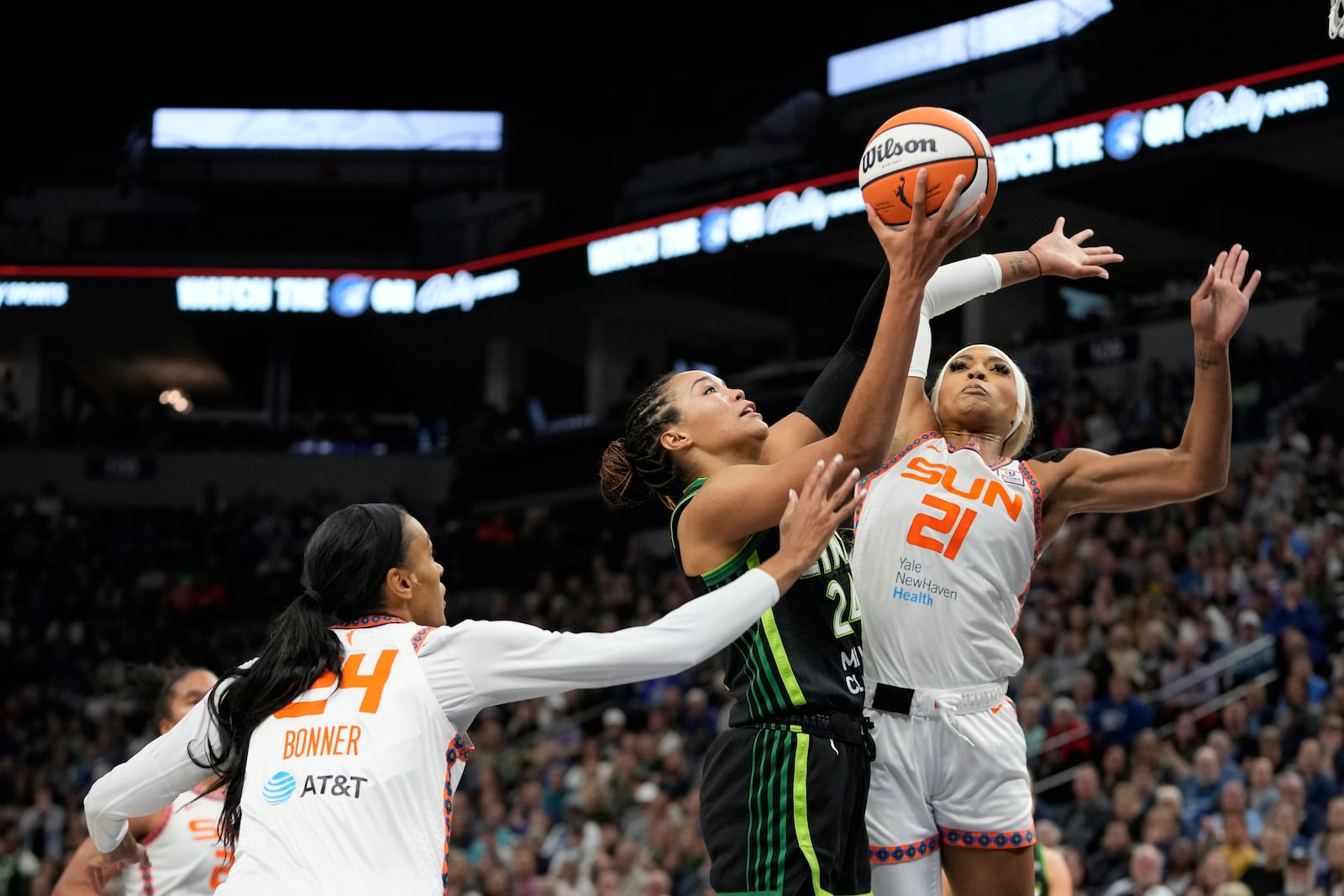 Minnesota Lynx forward Napheesa Collier, center, goes up for a shot as Connecticut Sun forward DeWanna Bonner (24) and guard DiJonai Carrington (21) defend during the second half of Game 5 of a WNBA basketball semifinals, Tuesday, Oct. 8, 2024, in Minneapolis. (AP Photo/Abbie Parr)