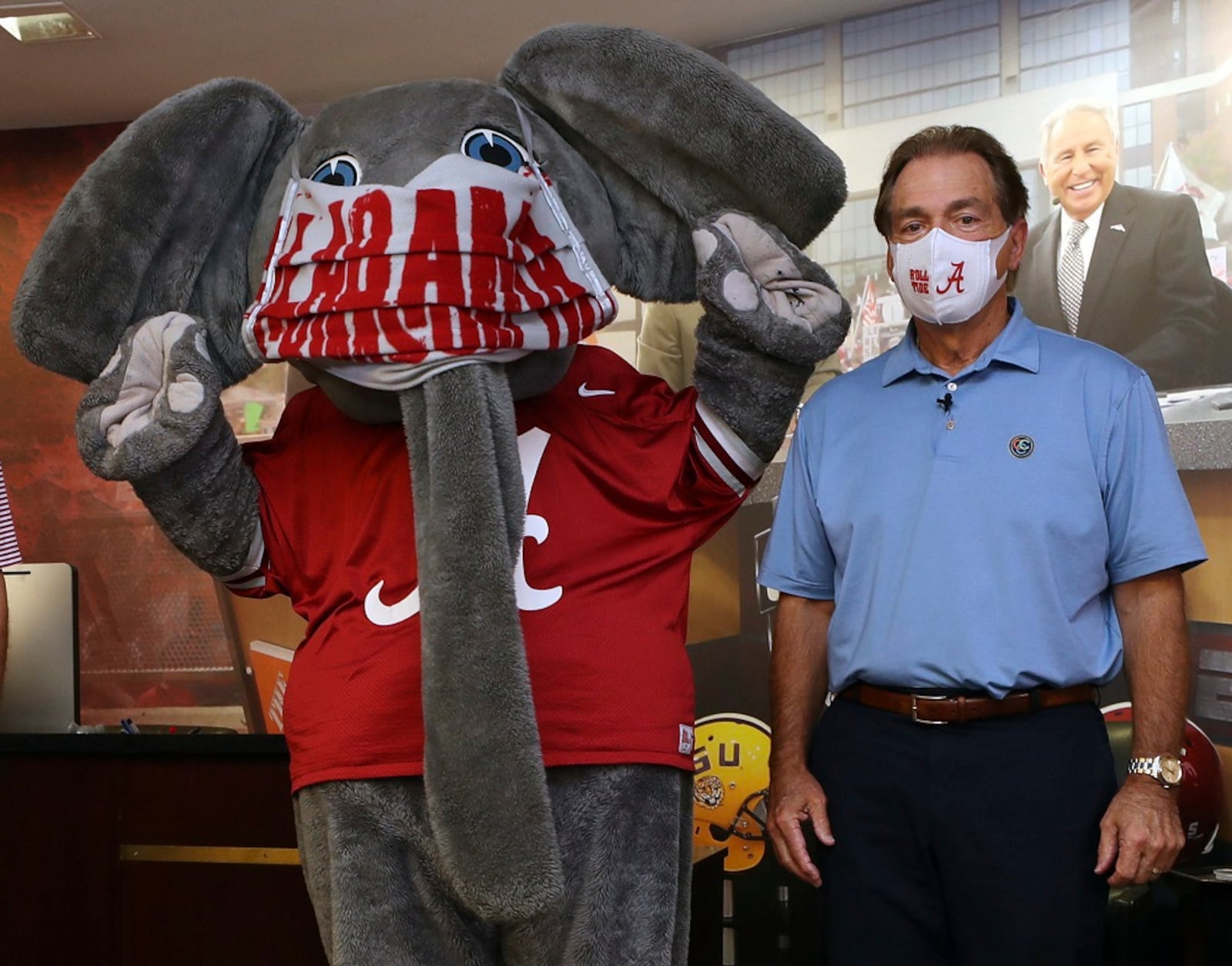 In this May 20, 2020 photo provided by the University of Alabama, football coach Nick Saban and the school's elephant mascot, Big Al, wear masks on the university campus in Tuscaloosa. Saban recorded a video promoting the use of face masks and social distancing. (AP Photo/Kent Gidley, University of Alabama via AP)