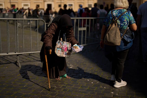 A woman begs for alms at St. Peter's Square at the Vatican, Friday, March 7, 2025. (AP Photo/Francisco Seco)