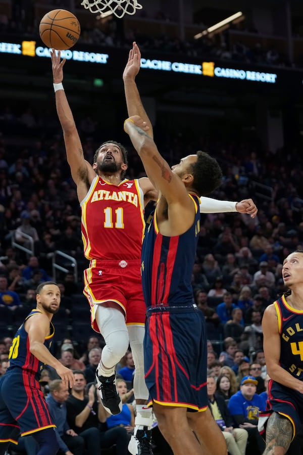 Atlanta Hawks guard Trae Young (11) shoots while defended by Golden State Warriors forward Kyle Anderson, right, during the first half of an NBA basketball game Wednesday, Nov. 20, 2024, in San Francisco. (AP Photo/Godofredo A. Vásquez)