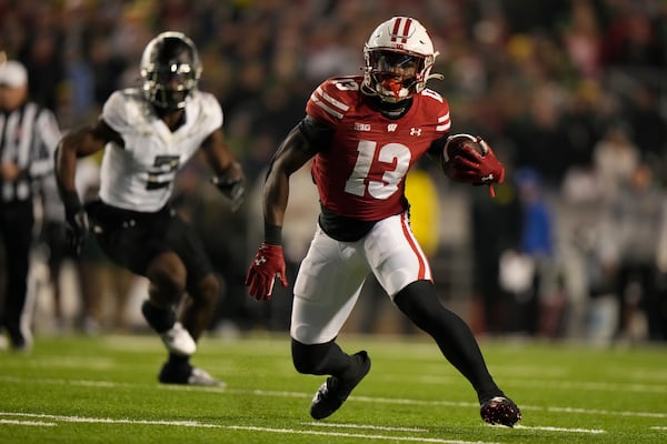 Wisconsin's Darrion Dupree (13) tries to get away from Oregon's Jeffrey Bassa (2) during the second half of an NCAA college football game Saturday, Nov. 16, 2024, in Madison, Wis. Oregon won 16-13. (AP Photo/Morry Gash)