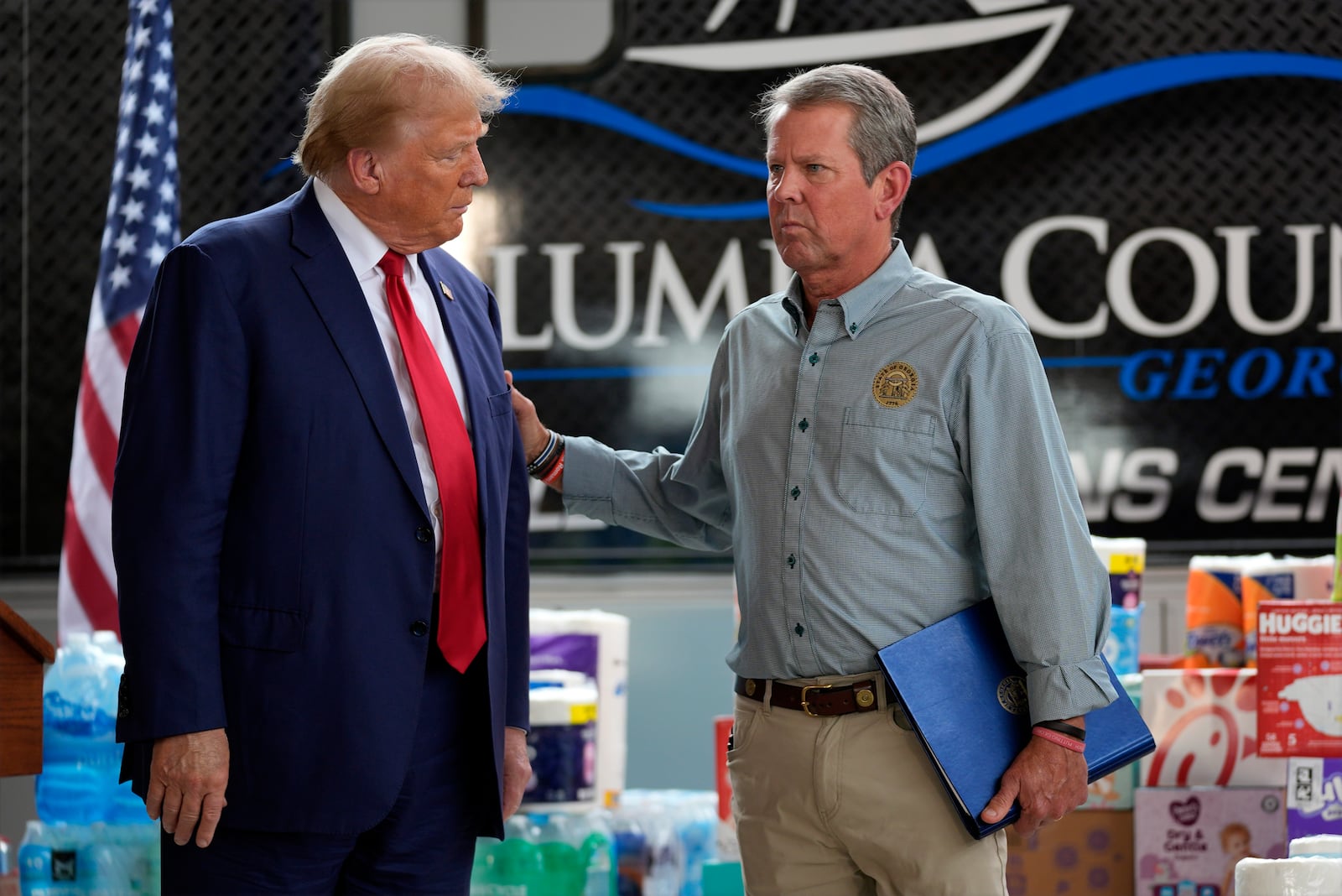 Republican presidential nominee former President Donald Trump is joined by Georgia Gov. Brian Kemp at a temporary relief shelter as he visits areas impacted by Hurricane Helene, Friday, Oct. 4, 2024, in Evans, Ga. (AP Photo/Evan Vucci)