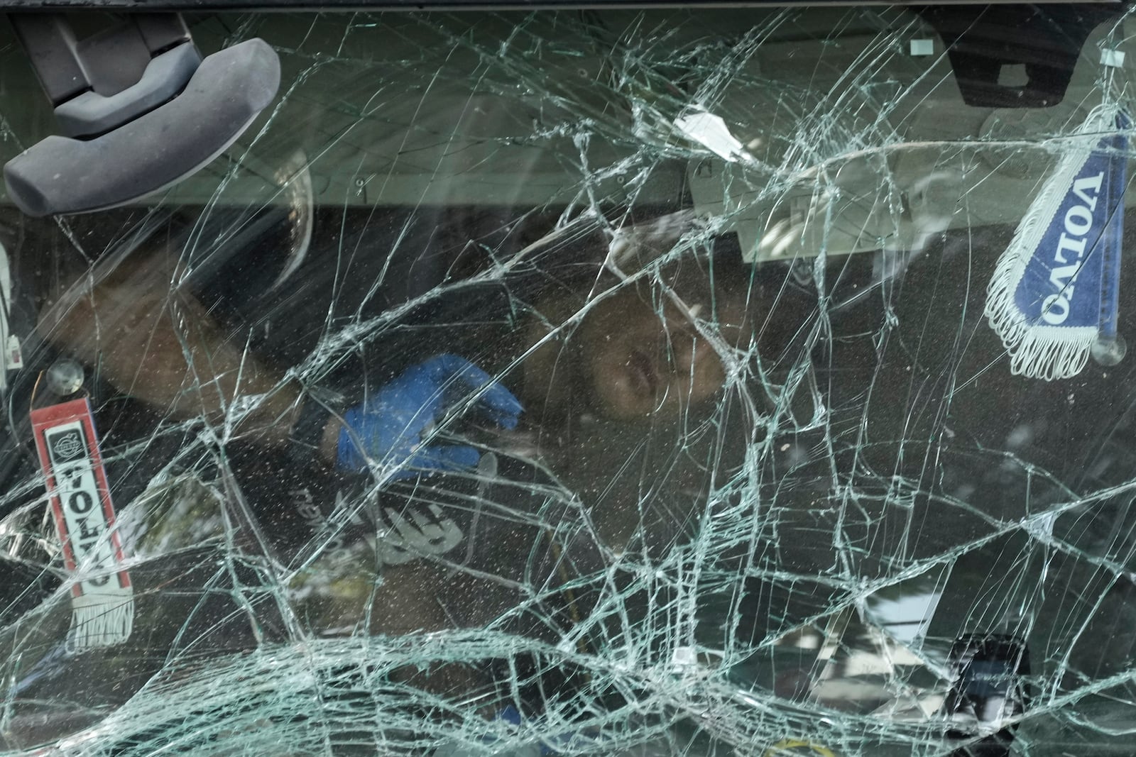 An Israeli police officer inspects inside the cabin of a truck that rammed into a bus stop near the headquarters of Israel's Mossad spy agency, wounding dozens of people, according to Israel's Magen David Adom rescue service in Tel Aviv, Israel, Sunday, Oct. 27, 2024. (AP Photo/Oded Balilty)