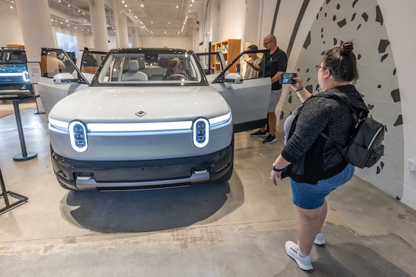 Sabrina Eijan takes a photograph of the new Rivian R2 prototype that will eventually be made in Georgia at the Ponce City Market in Atlanta on April 27, 2024.  (Steve Schaefer / AJC)